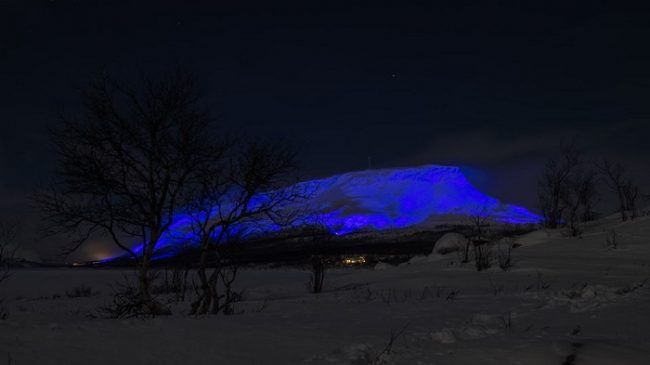 La colina de Saana en Kilpisjärvi iluminada de azul 