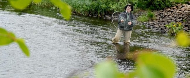 Mujer pescando en uno de los numerosos ríos que hay alrededor de la ciudad de Kuusamo 